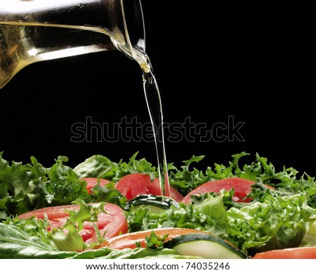 Pouring olive oil and fresh salad.