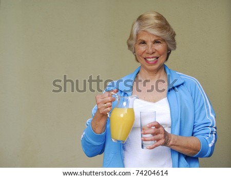 Mid adult woman drinking orange juice. Woman holding orange juice jar.