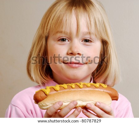 stock photo Little girl eating hot dogKid eating hot dog