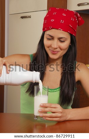 Young hispanic woman pouring milk,young woman drinking milk.