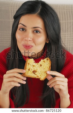 Hispanic young woman eating panettone,Young woman eating bread.