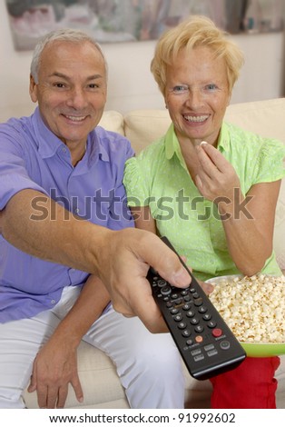 happy senior couple watching television together.Senior couple changing tv channels.