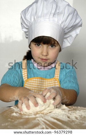 Little girl cooking a pizza in a kitchen.Little kid in a kitchen.