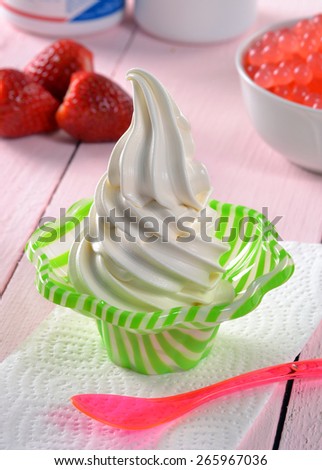 Vanilla ice cream cup and fruit ingredients on party background.