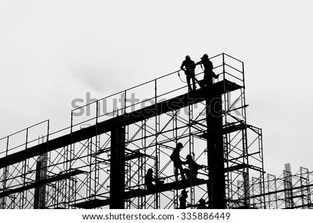 Silhouette of construction worker on scaffolding in the construction site before to night time.