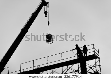 Silhouette of construction worker on scaffolding in the construction site.