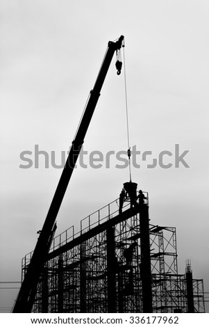 Silhouette of construction worker on scaffolding in the construction site.