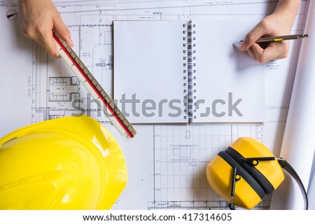 Engineer person working to building design concept with yellow helmet. Top view from above with copy space.