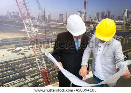 Management consulting with engineers working and holding blueprint engineer designer with helmet holding blueprint in his hand for management business plan.