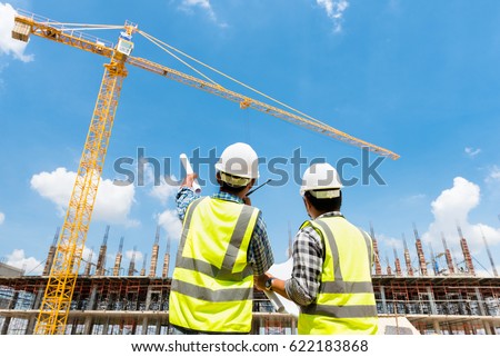 Civil engineer checking work with walkie-talkie for control and management in the construction site or building site of highrise building