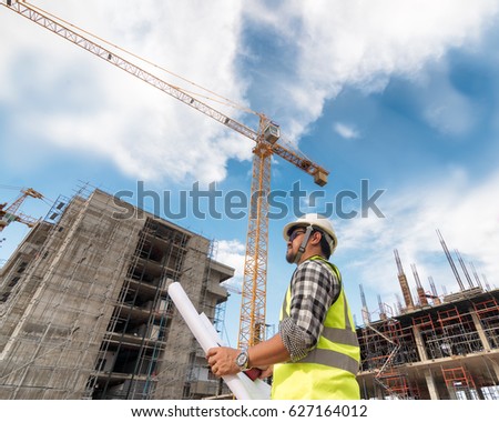 Engineering Consulting people on construction site holding blueprint in his hand. Building  inspector. Construction site check drawing and business workflow of new building