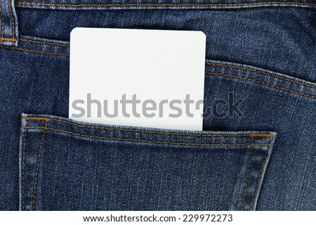 Part of white card paper in the front pocket of blue denim jeans