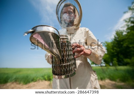 beekeeper with smoke tool\
making clouds