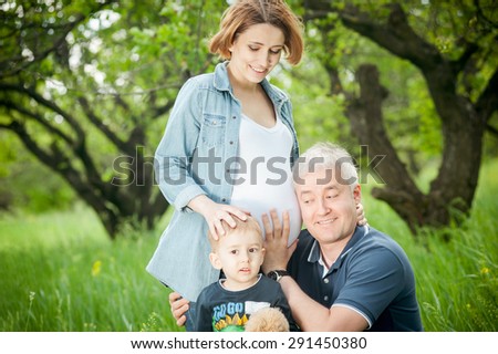 Happy family. Father and son listening pregnant mother\'s belly.