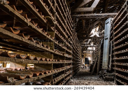 Rows of racks with roof tiles, left to dry or cool in an abandoned factory.