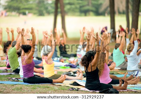 people doing yoga lesson in a park at sunset