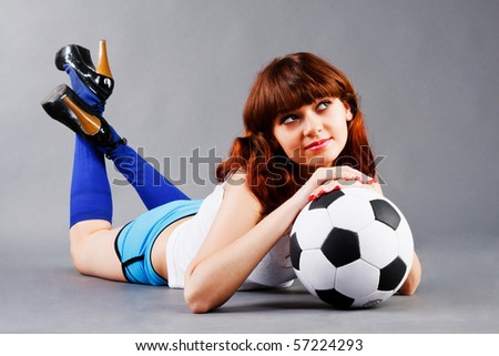 Lying young girl on floor with a soccer ball