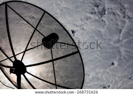 Satellite dishes communication technology network with sun and white cloud in background