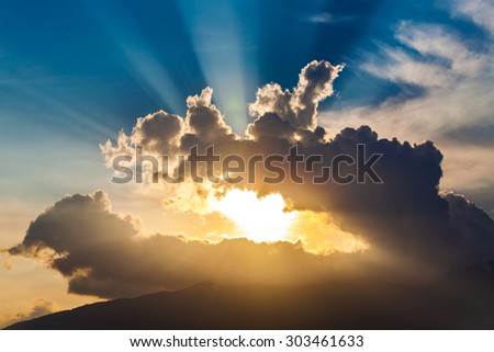 golden rays of the sun through the black clouds