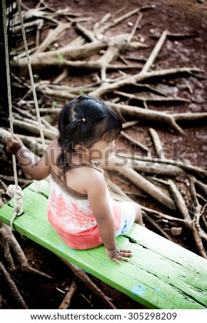 little girl play swing in garden