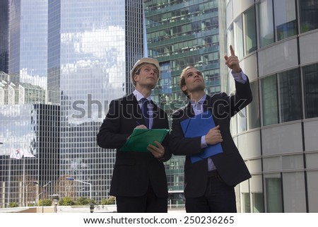 Two businessman pointing away