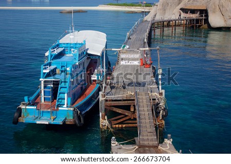 A wooden blue diving boat on the jetty of Nangyuan Island Resort