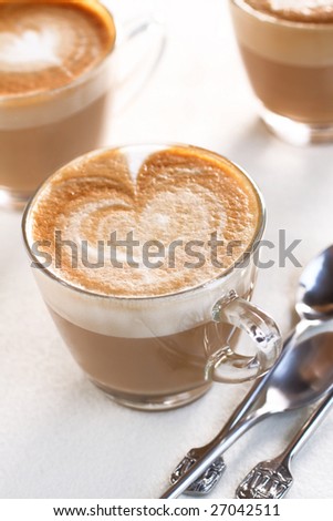 hot cappuccino coffee with coffee art on foam milk.