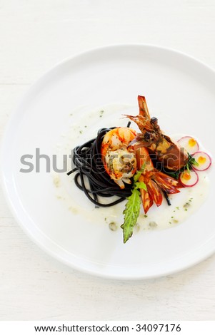 a dish of grilled prawn with salad and squid spaghetti, spread with white sauce and garnish with caviar.