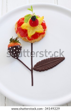 fruit tart with fresh fruit like starfruit,  styling with chocolate coated strawberry, like a flower tree.