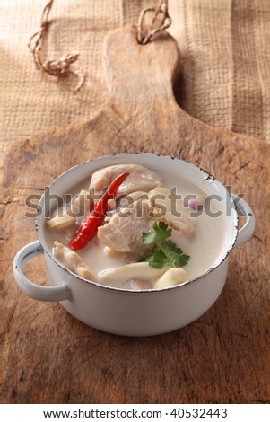 tom kha gai or coconut milk soup with chicken breast. The populat Thai menu, ready to serve in a white pot.