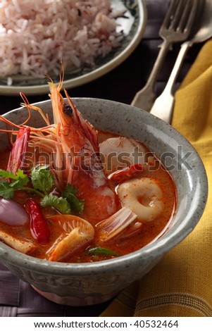 Tom Yum Kung or spicy tom yum soup with shrimp. Thai popular food menu, contained in an ancient bowl.