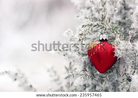 Red glass Christmas hearts on a snowy tree