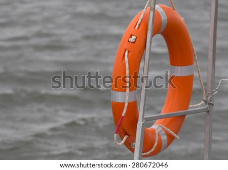 Red lifebuoy hanging on railings of rescue boat