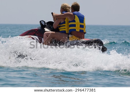 Portrait  young  couple riding jet ski on sea