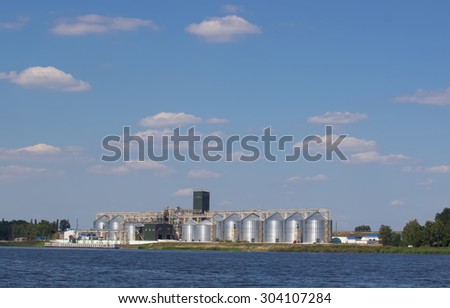 storage of grain near the water. Blue sky