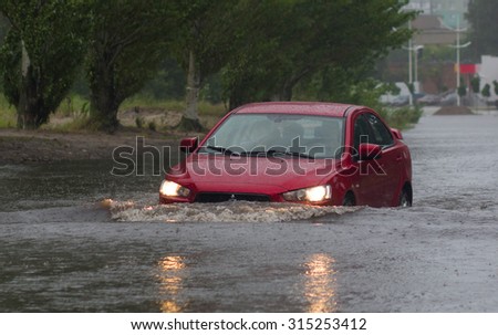 CHERKASSY, UKRAINE- JUNE 27, 2015: cars driving on a flooded road during a flood caused by heavy rain, in Cherkassy.