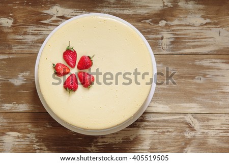 Caramel cheesecake with strawberry on the wooden background top view