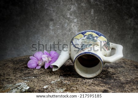 Still life vase and flower on weathered wooden background