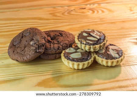 chocolate tart and soft dark chocolate brownie cookies on wooden