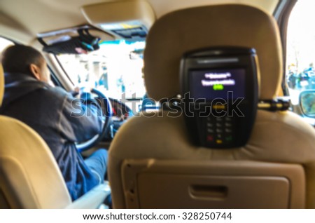 inside a taxi with money pay machine in front a back seat.-blur picture.