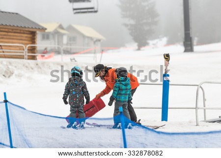 trainer teaching little boy and girl  how to mountain ski .