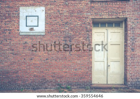 red old brick wall with door and basketball plate for background.
