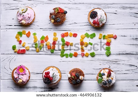 Beautiful cakes and candied fruit on a white wooden table. Table with food for the holiday.