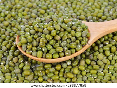 Mung beans in wooden spoon on mung beans background.