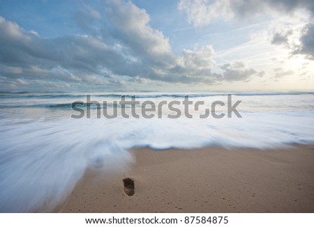 Footsteps washed away by a wave at the beach