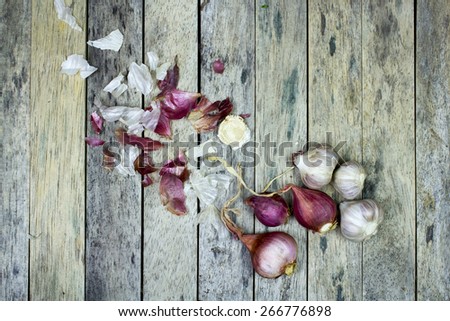 onion and garlic on wood plank, top view