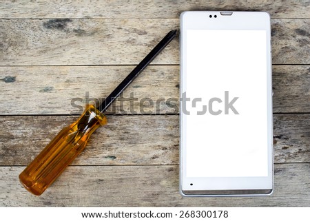 smart phone and screwdriver for repair on wood plank,  top view, white screen