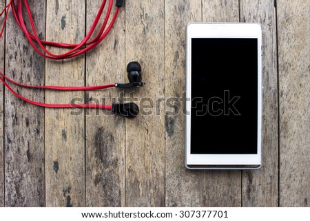 cellphone and earphone on wooden background, listening set