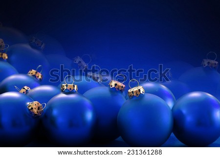 christmas background: many blue christmas baubles with golden loops, blurred in the background, copy space