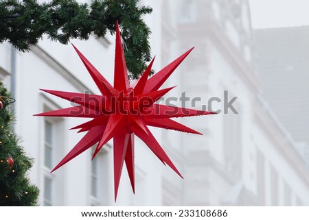 red christmas star outside with raindrops, street decoration in old town, copy space